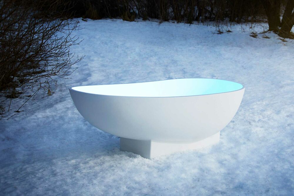 Copenhagen badekar fra Interform. Lekkert frittstående designbadekar i hvit matt kompositt / Solid surface. Baderommets smykke. Klikkventil i samme utførelse som badekaret. Ute i vinter og snø.