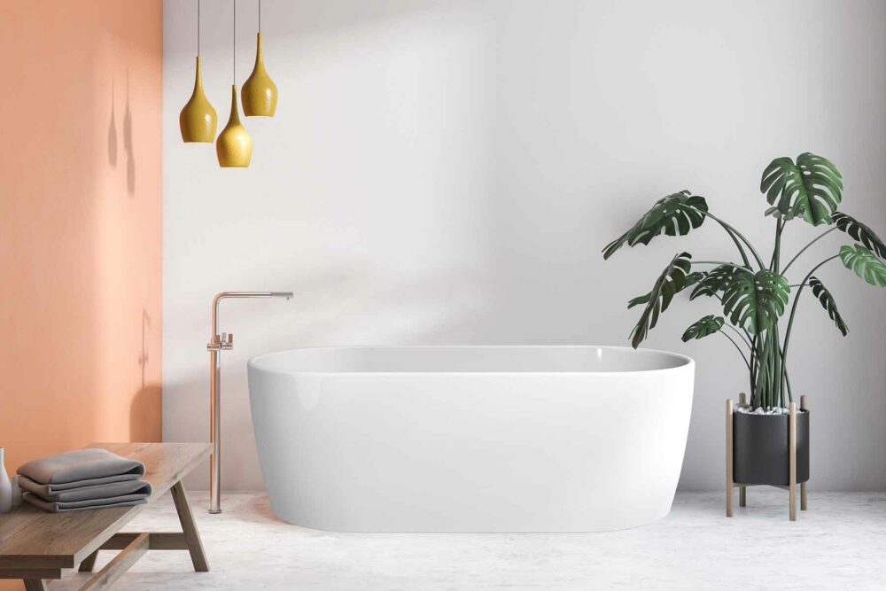 Embla helstøpt badekar fra Interform i hvit akryl. Gulvarmatur i krom. Betong gulv med marmor look og gule pendel lamper. Aprikosfarget vegg