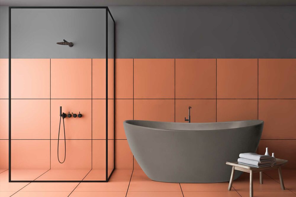 Viena "betong look" badekar fra Interform i grå matt kompositt / solid surface. Terracotta farge på flis. Svart dusjvegg og svart armatur.