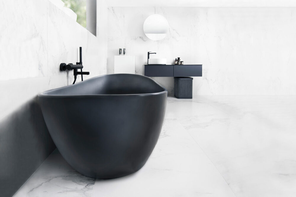 Viena Svart er et lekkert frittstående badekar. Svart vegg armatur. Det ovale designet skaper et mykt og moderne uttrykk. Utførelsen i svart matt kompositt gjør dette til et blikkfang. Marmor gulv og vegg. utsikt fra badekar. Svart innredning