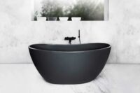 Viena Svart er et lekkert frittstående badekar. Svart vegg armatur. Det ovale designet skaper et mykt og moderne uttrykk. Utførelsen i svart matt kompositt gjør dette til et blikkfang. Marmor gulv og vegg. utsikt fra badekar.