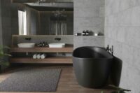 Viena frittstående badekar i svart matt med svart matt veggarmatur. Dobbel servant og stort speil. Gulvflis i treimitasjon og store flis på vegg i betongimitasjon